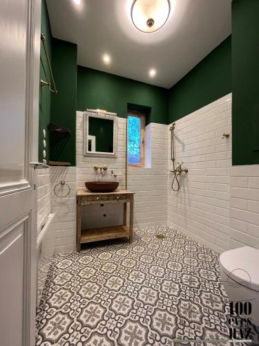 a bathroom with a sink and a toilet and green wall at 100 éves ház in Balatonakarattya