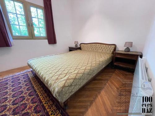 バラトンアカラッチャにある100 éves házのテーブルとベッドサイドシックスが備わる客室の小さなベッド1台分です。