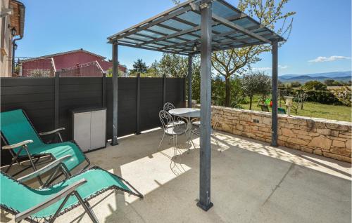 Una pérgola con dos sillas y una mesa en un patio. en Beautiful Home In Barjac With Wifi, en Barjac