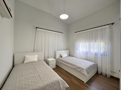 a bedroom with two beds and a window at New Heaven in Sea Caves in Peyia