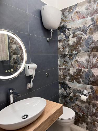 een badkamer met een wastafel en een spiegel bij La casa di Ale 69 in Napels