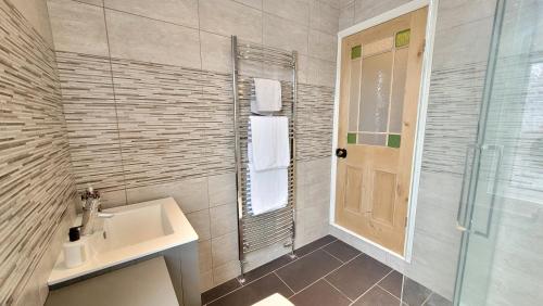 a bathroom with a sink and a shower at Colenso St - 2 bed house by Bishy Road & River in York