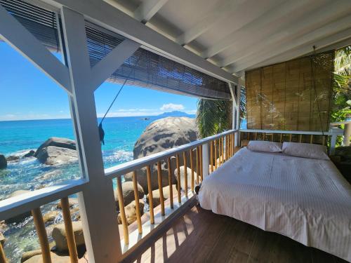 a bedroom with a bed and a view of the ocean at Marquise & Infinity villas in Glacis