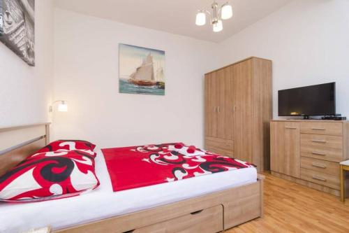 a bedroom with a bed with a dresser and a tv at Romantic studio apartment in Sobra