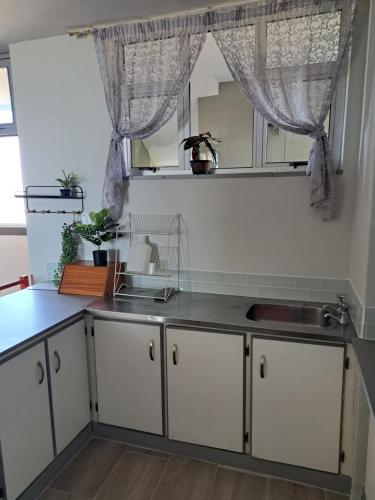 a kitchen with white cabinets and a sink at Sun Sea Sand Peacehaven Scottburgh in Scottburgh