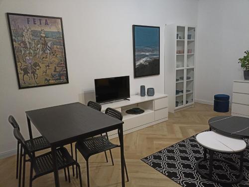 a living room with a table and chairs and a television at Zaciszny Apartament Old Town Gdansk in Gdańsk