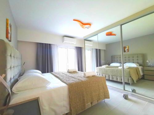 a bedroom with two beds and a large mirror at Mama Fox in Alepou