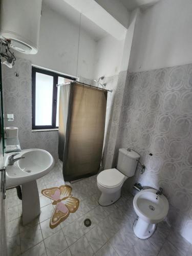 a bathroom with a toilet and a sink and a shower at Seashell Beach Rooms in Durrës