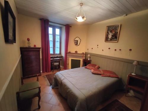- une chambre avec un lit et une cheminée dans l'établissement Domaine de La Croisée Verte, 3 maisons au coeur du Périgord, à Veyrines-de-Vergt