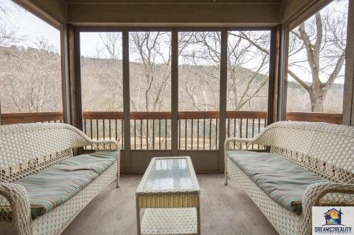 a screened in porch with two couches and a table at 3BR Condo with Lake View - Trout Fishing - Playground - 2 Pools - Stairs Required - FREE TICKETS INCLUDED - PR69-9 in Branson