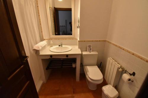 a bathroom with a sink and a toilet and a mirror at Casa Rural Almonaster la Real, Marques de Robledal in Almonaster la Real
