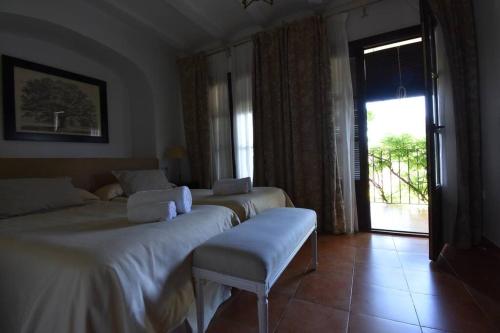 a hotel room with two beds and a sliding glass door at Casa Rural Almonaster la Real, Marques de Robledal in Almonaster la Real