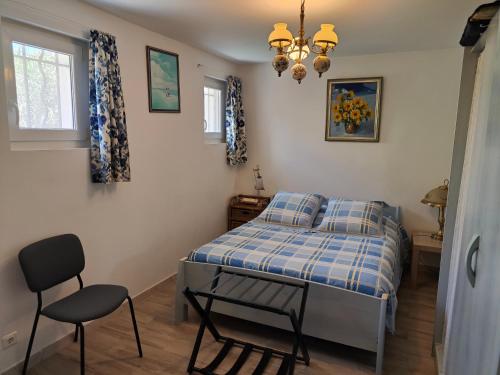 une chambre avec un lit et une chaise dedans dans l'établissement Etoile de Mer - Appt 3 ch 2 sdb à 150m d'une plage de sable fin hyper équipé & Wifi, à Saint-Mandrier-sur-Mer