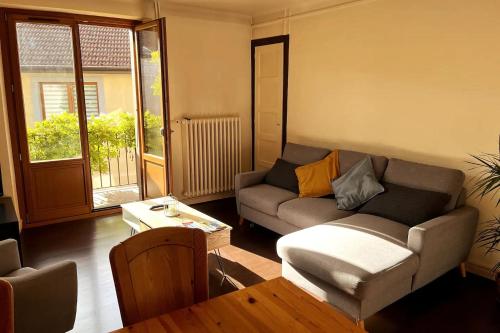 un salon avec un canapé et une table dans l'établissement Logements des Marmottons - Cœur de village à Bonne, à Bonne