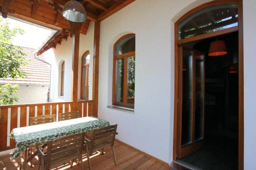 a patio with a table and chairs on a porch at Swiss villa in the Danube Bend in Nagymaros