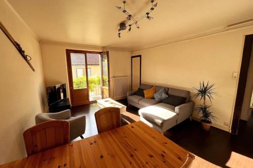 un salon avec un canapé et une table dans l'établissement Logements des Marmottons - Cœur de village à Bonne, à Bonne