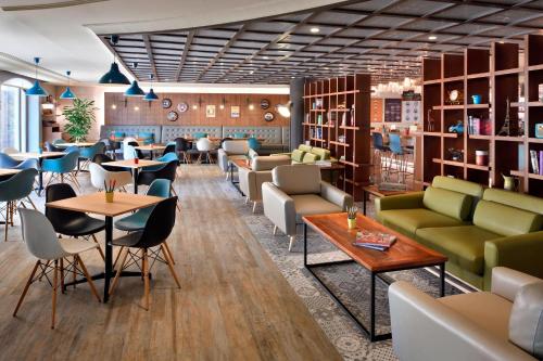 a restaurant with tables and chairs and bookshelves at Dead Sea Marriott Resort & Spa in Sowayma