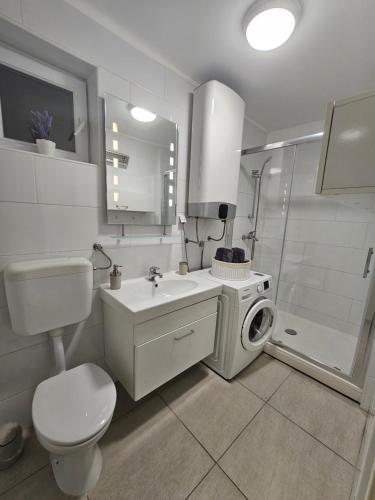 y baño con lavamanos y lavadora. en Apartment Aria, en Vinkovci