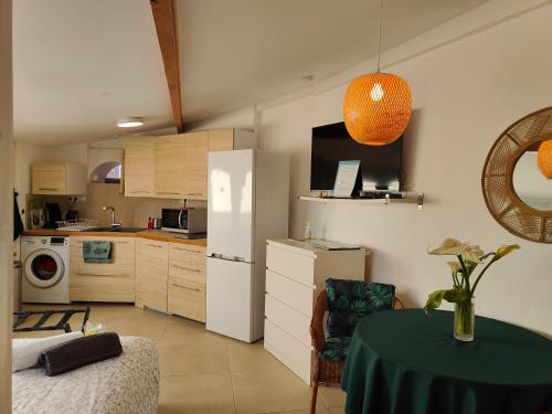 uma cozinha com uma mesa e um frigorífico branco em Petite étoile de Mer - Studio hyper équipé à 150m d'une plage de sable fin grande terrasse presqu'île de charme em Saint-Mandrier-sur-Mer