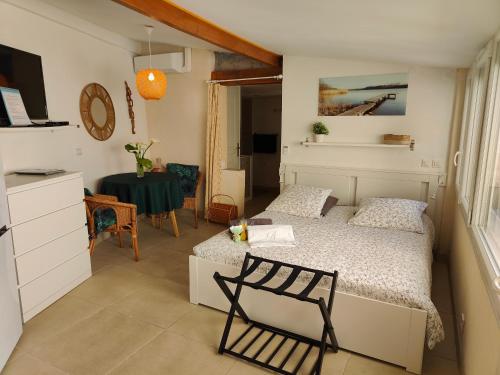 um quarto com uma cama, uma mesa e uma cadeira em Petite étoile de Mer - Studio hyper équipé à 150m d'une plage de sable fin grande terrasse presqu'île de charme em Saint-Mandrier-sur-Mer