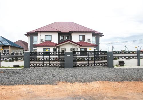 a house with a black gate in front of it at THE GRANGE HOTEL GHANA in Dawhwenya
