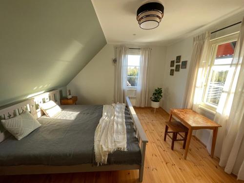 a bedroom with a bed and a table and two windows at Kivika in Lahe