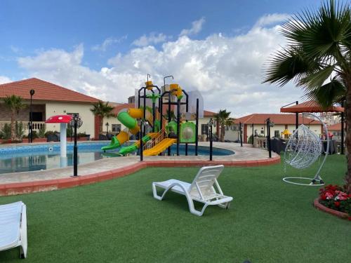 a pool with a playground with a slide at منتجع الجزيرة الخضراء in Al Hada