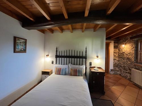 Casa Rural O Vilar في Mera de arriba: غرفة نوم بسرير كبير في مبنى