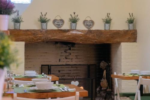 een eetkamer met een open haard, tafels en stoelen bij Eco Soul Ericeira Guesthouse - Adults Only in Ericeira