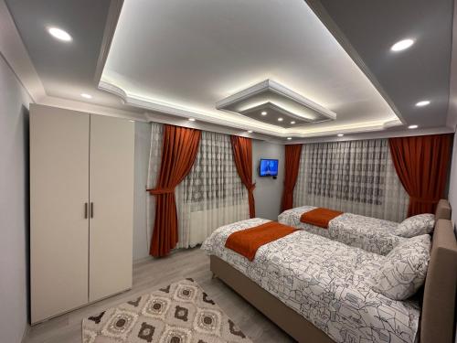 2 camas en un dormitorio con cortinas rojas en Pocibükensarayları en Çamlıhemşin
