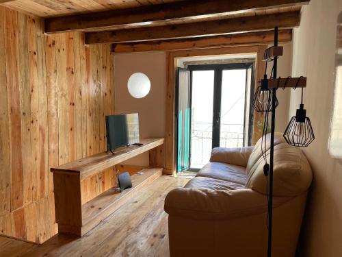 a living room with a couch and a television at Casas do Miradouro in Setúbal
