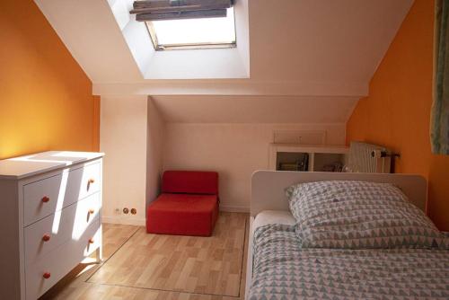 - une chambre avec un lit et une chaise rouge dans l'établissement Villa Manarola - 10pers/4Ch - jacuzzi & jardin, à Longjumeau
