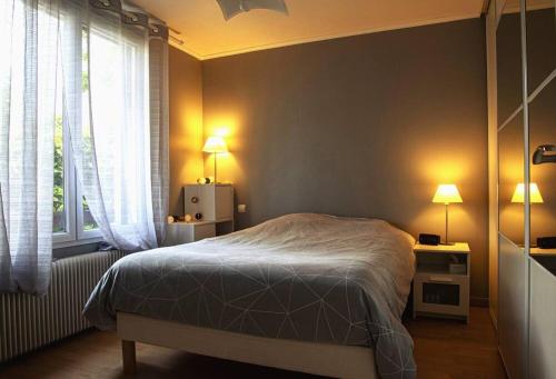 a bedroom with a bed and a window with two lamps at Villa Manarola - 10pers/4Ch - jacuzzi & jardin in Longjumeau