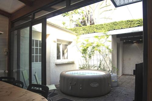 a large tub sitting in the middle of a patio at Villa Manarola - 10pers/4Ch - jacuzzi & jardin in Longjumeau