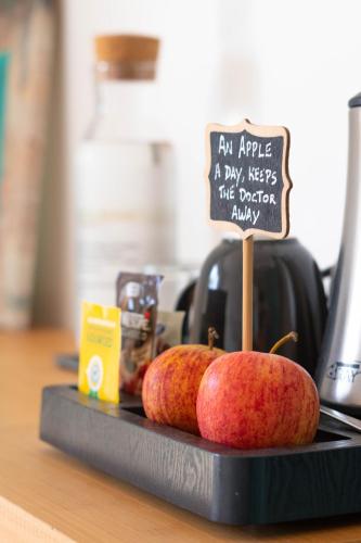 two apples on a counter with a sign on it at Eco Soul Ericeira Guesthouse - Adults Only in Ericeira