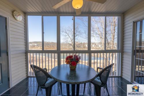 a table and chairs on a screened in porch with windows at 2BR Walk-In Condo - Near The Strip - FREE TICKETS INCLUDED - CH1-18 in Branson