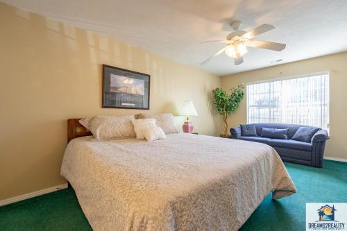 a bedroom with a bed and a couch and a ceiling fan at 2BR Walk-In Condo - Near The Strip - FREE TICKETS INCLUDED - CH1-18 in Branson