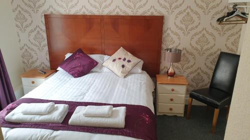 a bedroom with a bed with purple and white pillows at HOTEL242 in Blackpool