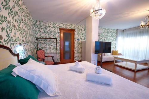 a bedroom with a large bed with two towels on it at Apartamentos Chvictoria in Cuenca