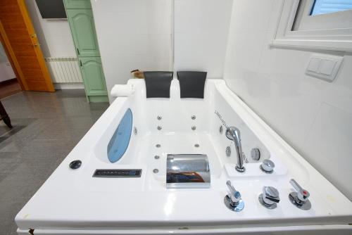 a bathroom with a bath tub with a sink at Apartamentos Chvictoria in Cuenca