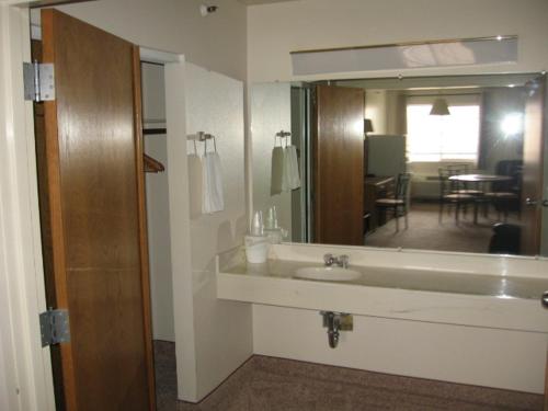 La salle de bains est pourvue d'un lavabo et d'un grand miroir. dans l'établissement Little Bear Motel, à Green River