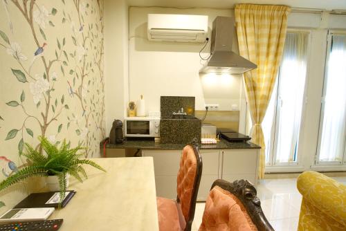 a small kitchen with a table and a microwave at Apartamentos Chvictoria in Cuenca