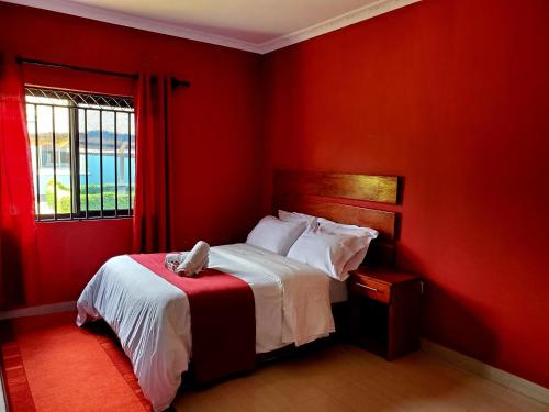 a red bedroom with a bed with a dog laying on it at Sweet Retreat-1 in Lusaka