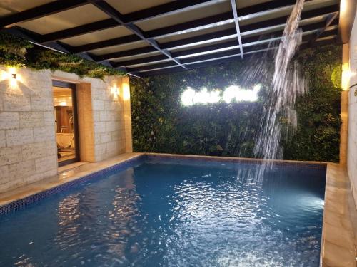 a swimming pool with a waterfall in a backyard at Melissa Hotel in Oran