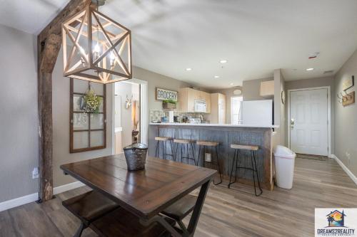 a dining room and kitchen with a wooden table at 3BR Updated Walk-In Condo - Near the Strip - FREE TICKETS INCLUDED - CH4-4 in Branson