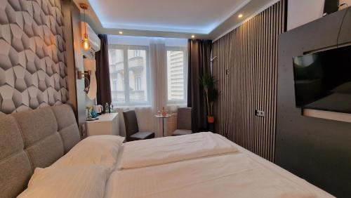 a bedroom with a bed and a flat screen tv at Elegance Wien in Vienna