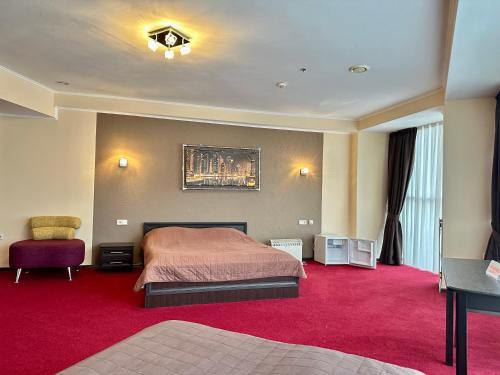 a bedroom with a bed and a red carpet at Mark Plaza Hotel in Mykolaiv