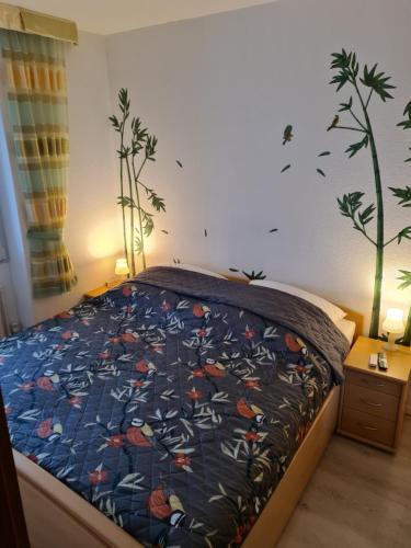 a bedroom with a bed with a bedspread with birds on it at Heiligenhafen Ostseeblick Aquamarina 57 in Heiligenhafen