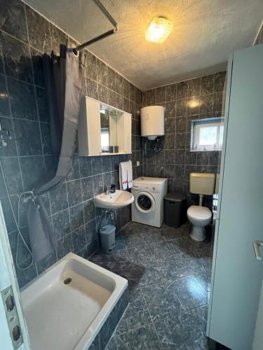 La salle de bains est pourvue d'une baignoire, d'un lavabo et de toilettes. dans l'établissement Apartment Ana, à Imotski