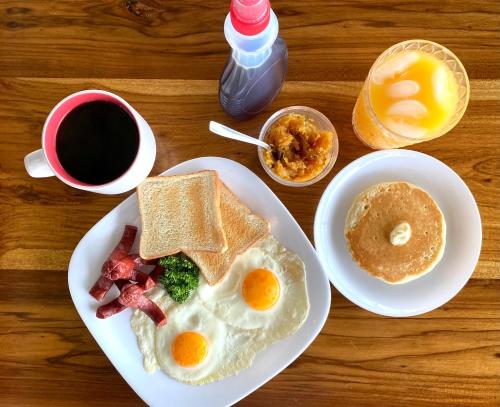 a table with a plate of breakfast foods and a cup of coffee at La Piña, Rio Celeste in Rio Celeste